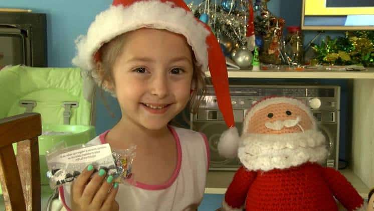 India tiene seis años y con ayuda de su papá regaló tarjetitas navideñas en el colectivo